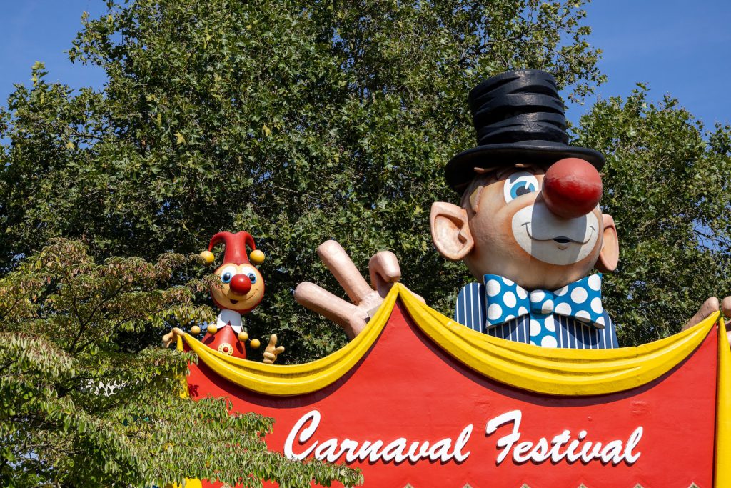 a carnival sign with a clown and clowns on it